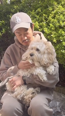 飼い主さんにだっこされる犬