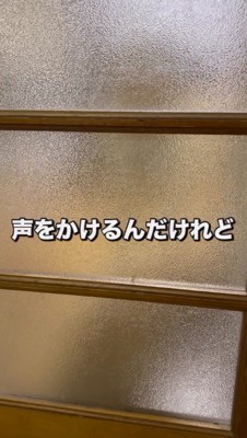 ドアの向こうでお座りをする犬