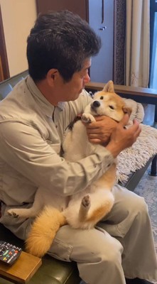 犬を膝の上に乗せる男性
