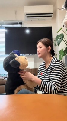 犬のぬいぐるみを持つ女性