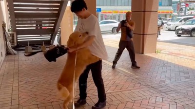 男性の足に抱きつく犬