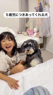 犬にお手をしてもらって笑顔になる女の子