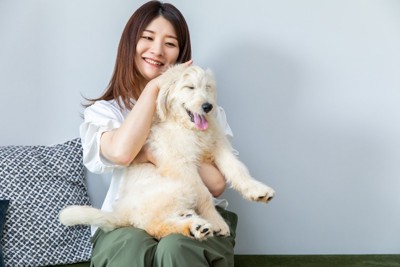 犬の頭を撫でる笑顔の女性