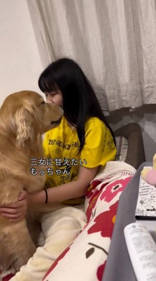 女の子の顔に顔を近づける犬