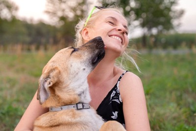 女性の顔を舐める犬