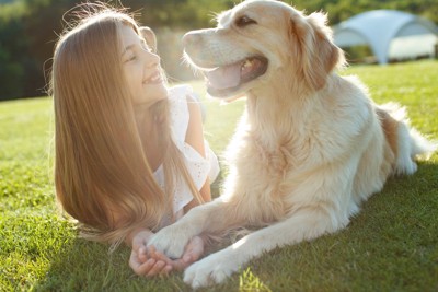 寝そべる女の子と犬