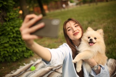 女性に写真を撮られている犬