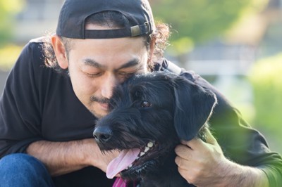 犬を抱き寄せる男性