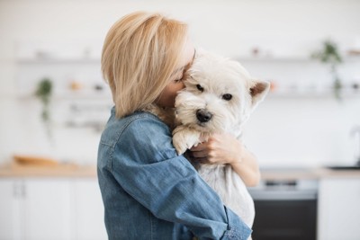 抱き付く飼い主に不安げな犬