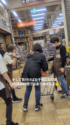 犬の周りに集まる店員と客