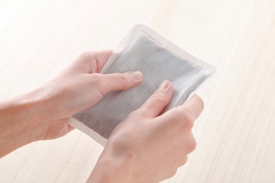 カイロで手を温める女性