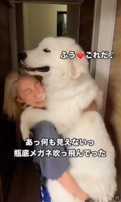 苦しそうな顔をしながら犬を抱っこする女性