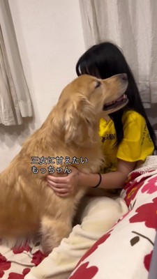 女の子に体を寄せる犬