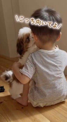 男の子の顔に飛びつく子犬