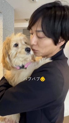 子犬にキスをする男性