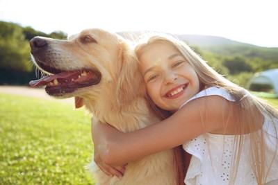 少女に抱きつかれる笑顔の大型犬