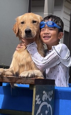 プールで犬に抱きつく人