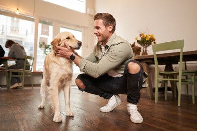 穏やかに犬を撫でる男性