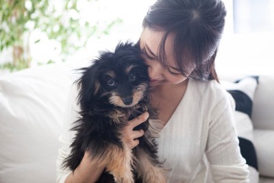 子犬を抱き寄せる女性