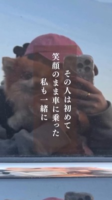 車の前で犬を抱っこする女性