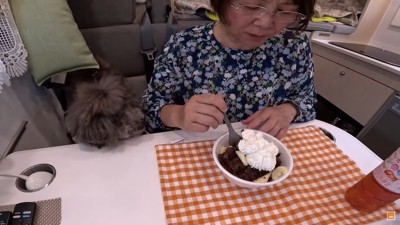 おやつを食べる女性と犬