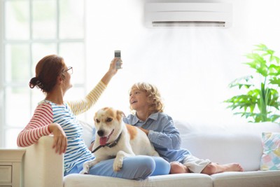 エアコンを操作する家族と犬