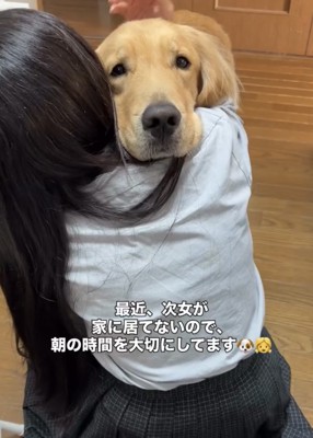 女の子の肩に顔を乗せる犬
