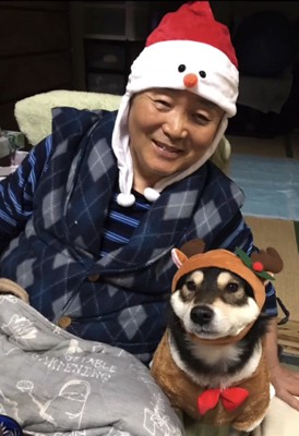 サンタとトナカイの仮装をするおじいちゃんと犬