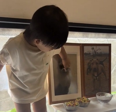 立って遺影を見つめる子ども