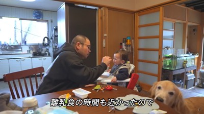 離乳食をあげる様子を見守る犬