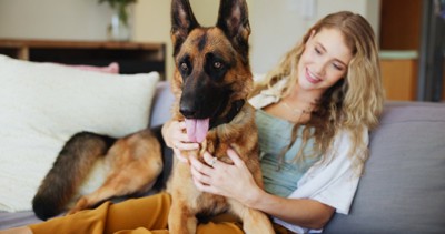 笑顔で女性の上に座る犬
