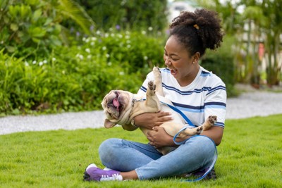 女性に抱っこされる犬