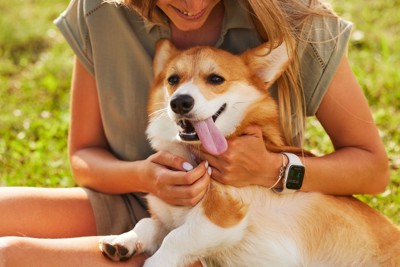 犬を抱きかかえてる女性