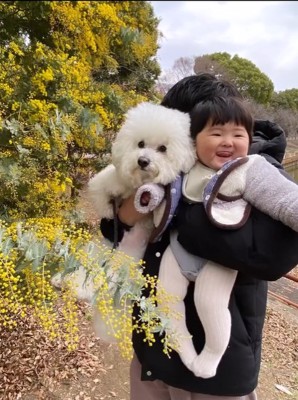 抱っこされる赤ちゃんと小型犬