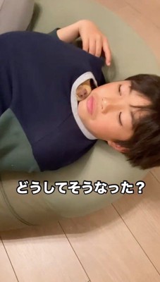 男の子の服の間から鼻を出す犬