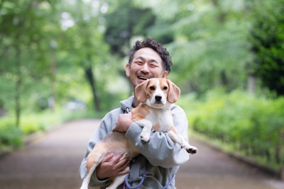 犬を抱っこする男性