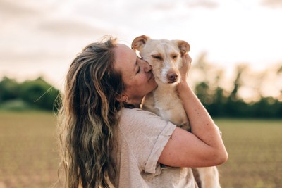 女性にキスされている犬