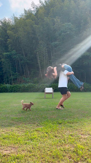 女性を肩に担ぐ男性を追いかける犬