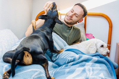 犬と寝る男性
