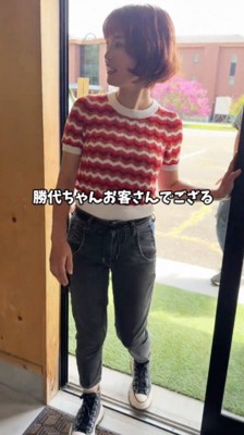 お店のドアから店内に入る若い女性