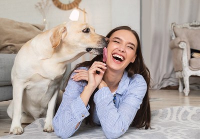 女性の顔を舐める犬