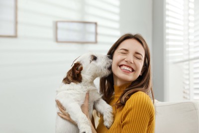 女性の顔にキスする犬