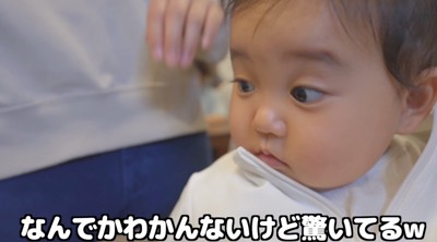 犬におやつを食べてもらえて、驚いた表情になる赤ちゃん