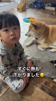 床に座ってカメラを見つめる男の子