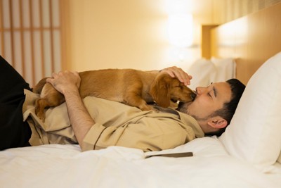 男性の上に乗る犬