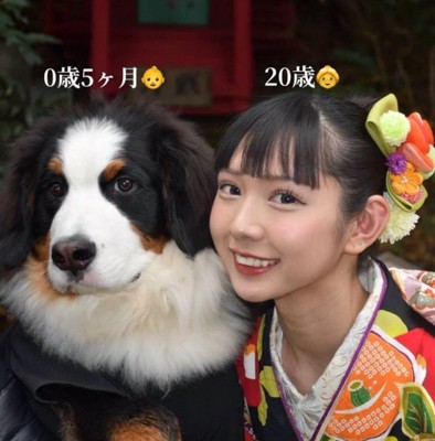 並んで写真を撮る子犬と女性