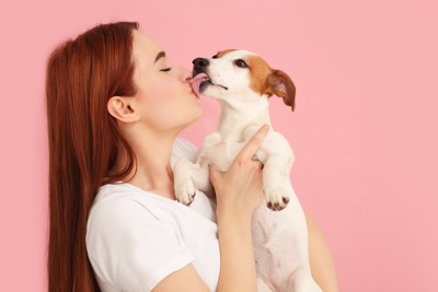 女性の顔を舐める犬