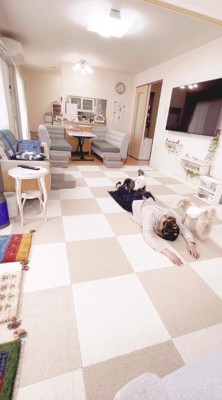 飼い主の足の間に乗る黒い犬