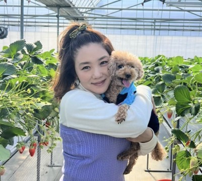 いちご畑で犬を抱く女性