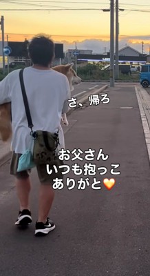 夕焼け空の中を帰る犬と人の後ろ姿